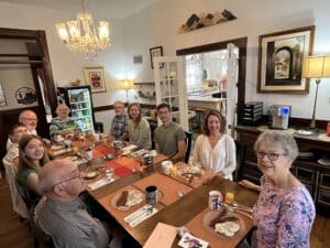 Family gathered around the dining room table at Alpine Bed and Breakfast for breakfast while celebrating a daughter and granddaughter's college graduation.