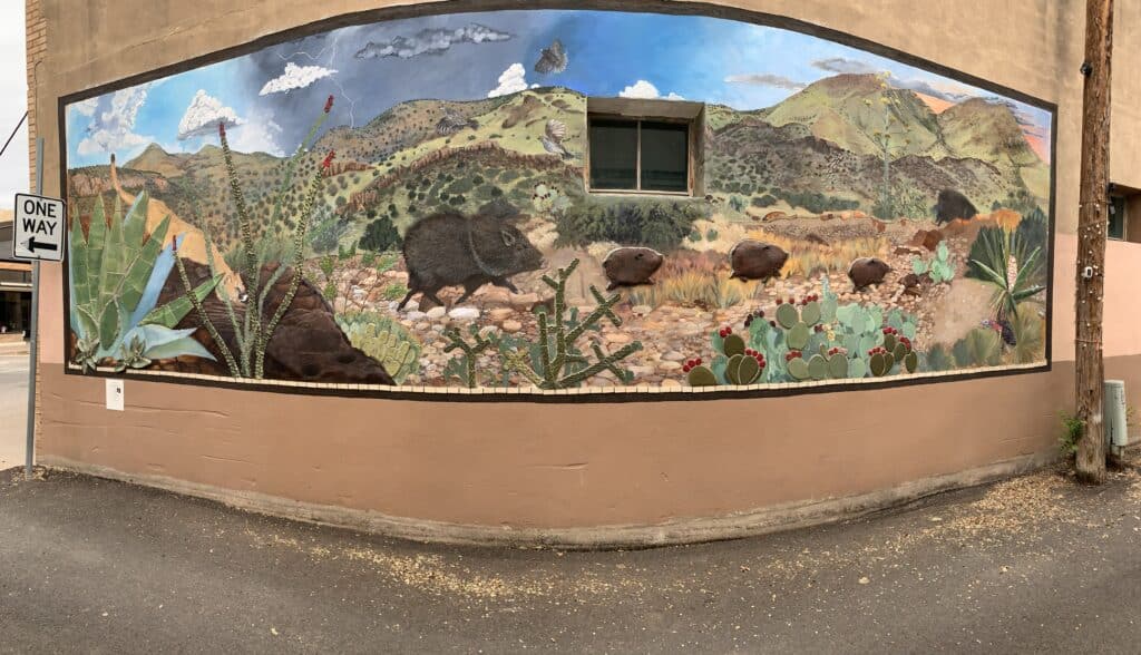 A wide angle shot of a mural that includes cacti, javalinas, a mountain lion, and other depictions of the West Texas deser.