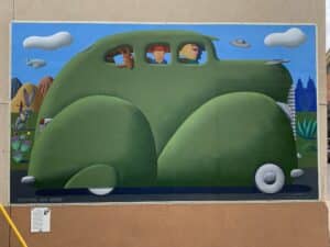 Mural of a green car with a family inside, taking a road trip