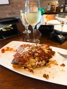 Lasagna on a plate and wine in a glass