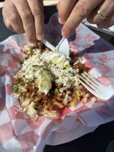 mexican food covered in beans, crema, avocado, lettuce, meat