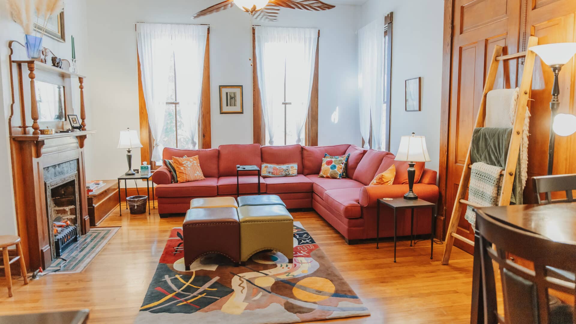 living room with a couch, ottomans, fireplace, rug and lights