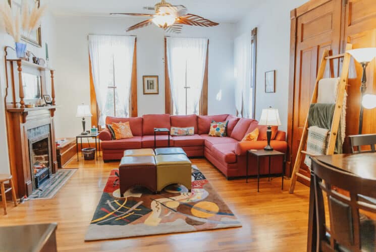 living room with a couch, ottomans, fireplace, rug and lights