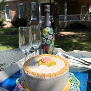 A decorated cake with two champagne glasses and a champagne bottle.