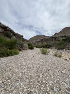 A dry river bed surrounded by rocky hills