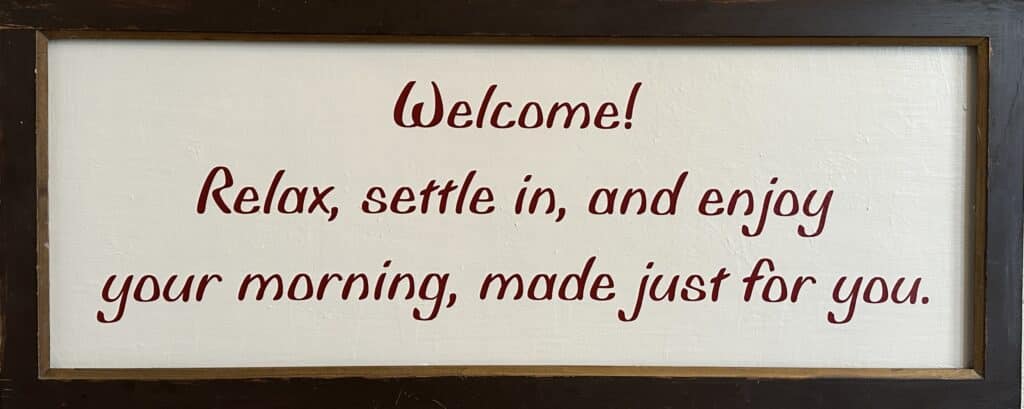 A sign that says Welcome! Relax, settle in, and enjoy your morning, made just for you.