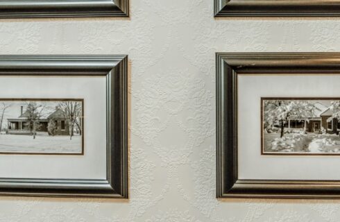 Gallery wall of pictures of a home in silver frames on a white wall