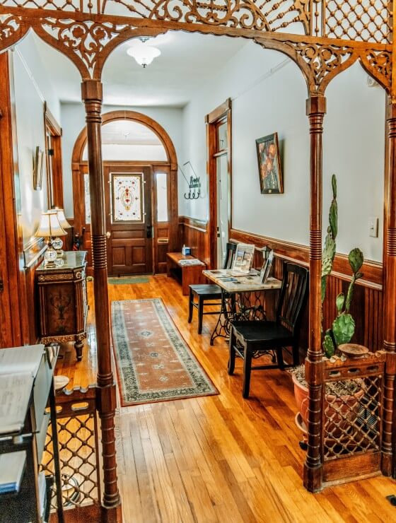 Front foyer hallway of an elegant home with rich wood detail and decorative archway