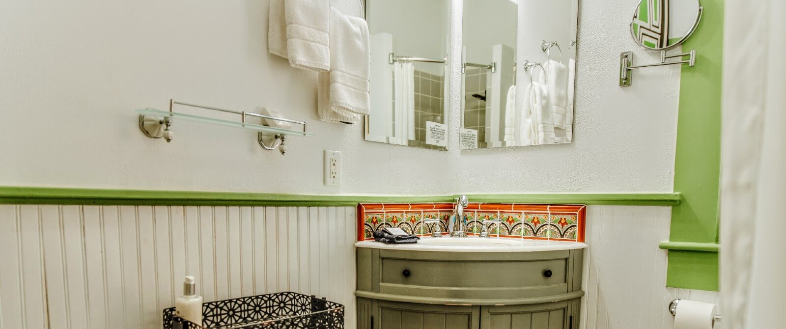 Bathroom with green trim, corner sink and mirrors and white shower curtain