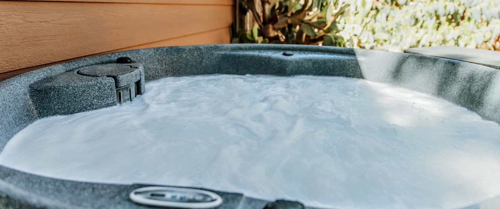 A round outdoor hot tub with bubbly water